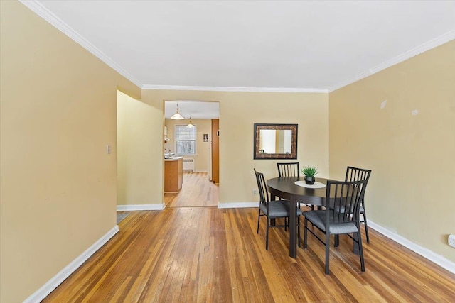 dining area featuring hardwood / wood-style flooring and crown molding