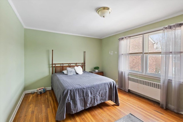 bedroom with hardwood / wood-style flooring, ornamental molding, and radiator