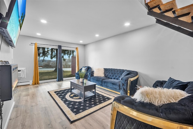 living area with recessed lighting, a baseboard radiator, a wall unit AC, and light wood-style floors