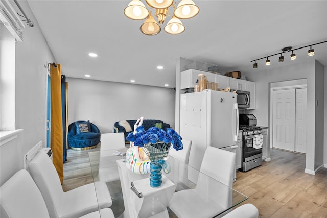 dining area with recessed lighting, rail lighting, an inviting chandelier, light wood-style floors, and baseboards