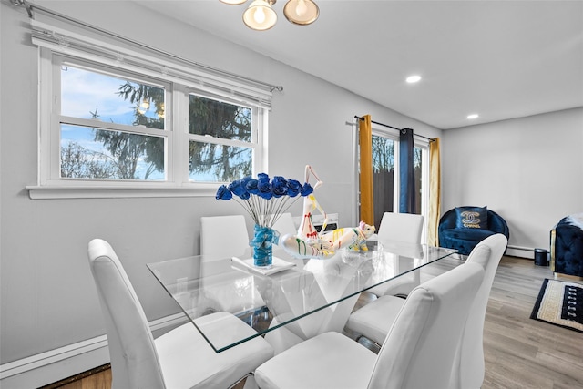 dining room featuring a healthy amount of sunlight, a baseboard radiator, wood finished floors, and recessed lighting