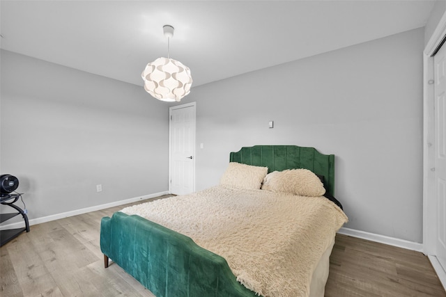 bedroom with wood finished floors and baseboards