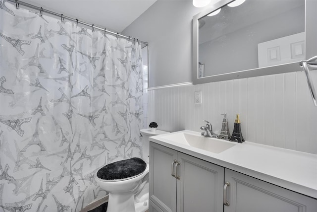 full bathroom with toilet, wainscoting, a shower with curtain, and vanity