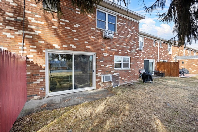 back of house featuring fence and brick siding