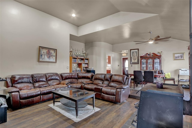 living room with dark wood-type flooring, ceiling fan, and vaulted ceiling