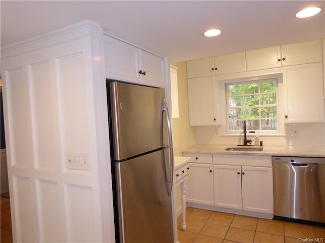 kitchen with sink, stainless steel appliances, white cabinets, and light tile patterned flooring