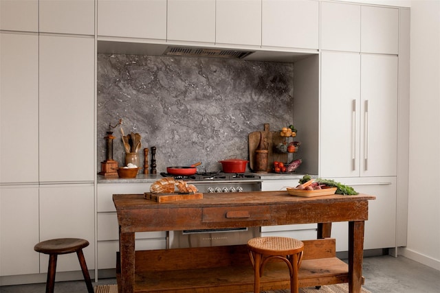 bar featuring range hood, backsplash, and built in refrigerator