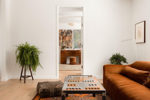 living area with baseboards and wood finished floors