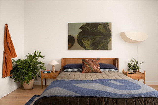 bedroom featuring baseboards and wood finished floors