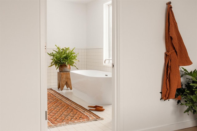 bathroom featuring a soaking tub and tile patterned floors