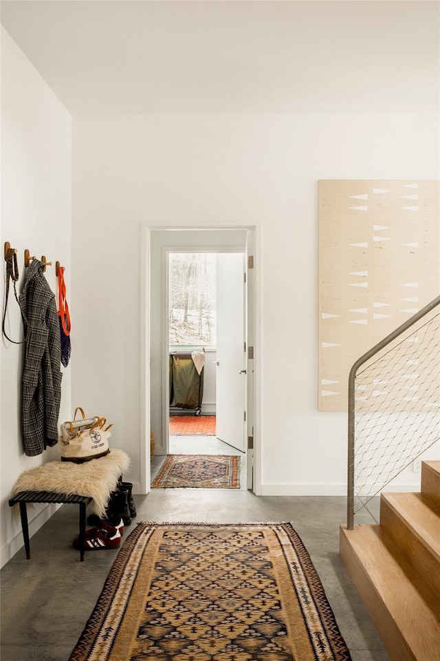 mudroom with baseboards and concrete flooring