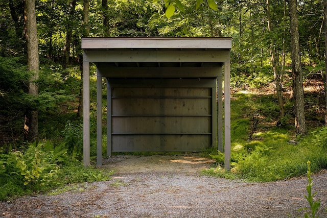 view of outdoor structure with an outbuilding, driveway, and a carport