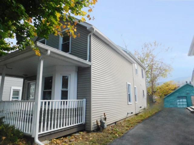 view of home's exterior featuring a porch and an outdoor structure