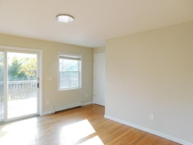 empty room featuring light hardwood / wood-style flooring and a baseboard heating unit