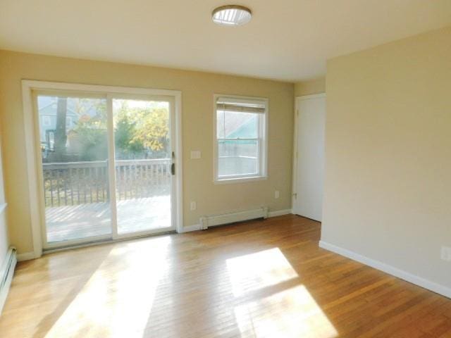 doorway featuring light wood-type flooring and a baseboard heating unit