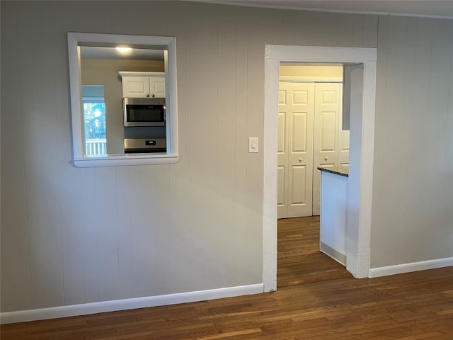 hallway with dark hardwood / wood-style flooring