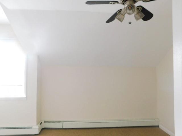 unfurnished room featuring a baseboard heating unit and ceiling fan