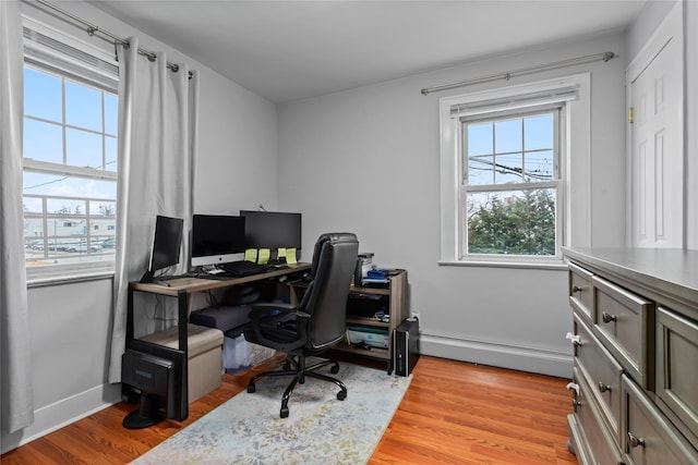 office space with light hardwood / wood-style floors and a baseboard heating unit