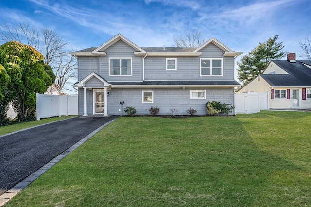 view of front of house featuring a gate, fence, and a front lawn