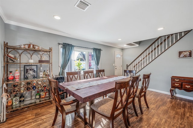 dining room featuring ornamental molding, wood finished floors, and baseboards