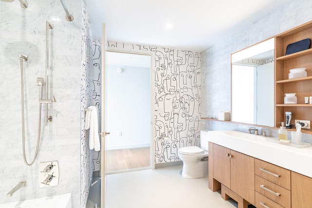 bathroom with vanity, toilet, and a tile shower