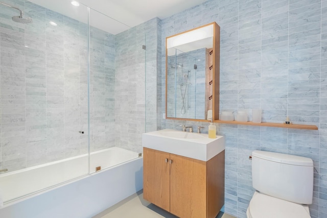 full bathroom with vanity, toilet, combined bath / shower with glass door, and tile walls