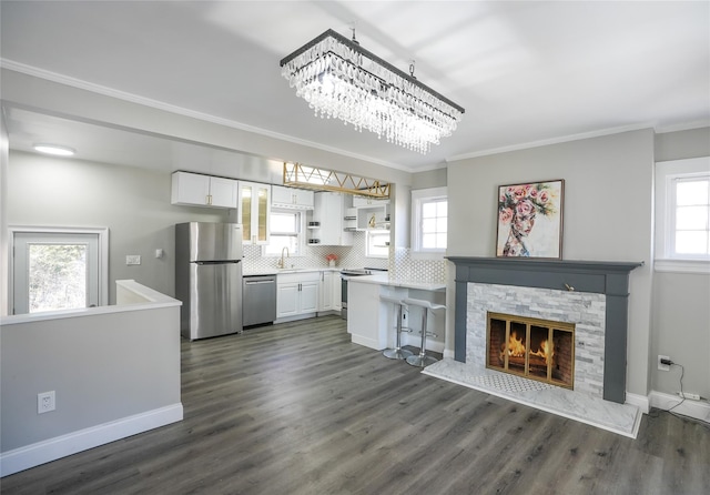 kitchen with crown molding, appliances with stainless steel finishes, sink, and white cabinets