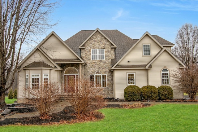 traditional home with stone siding, a front lawn, and a shingled roof