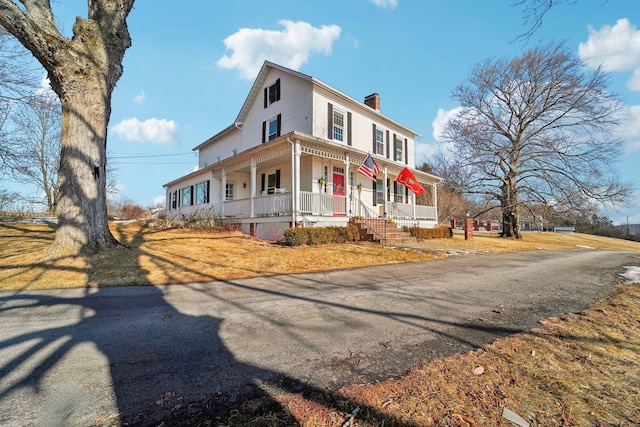 view of front of property with covered porch and a chimney