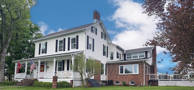 50 Maple Ave, Goshen, NY 10924 - view of front facade with covered porch, a front yard, a chimney, and brick siding