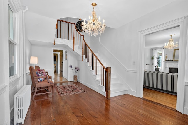 50 Maple Ave, Goshen, NY 10924 - entryway featuring radiator heating unit, a chandelier, hardwood / wood-style flooring, stairs, and a decorative wall