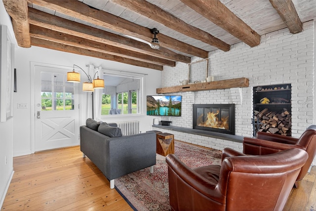 50 Maple Ave, Goshen, NY 10924 - living room with radiator heating unit, a brick fireplace, light wood-style flooring, and a wooden ceiling with exposed beams