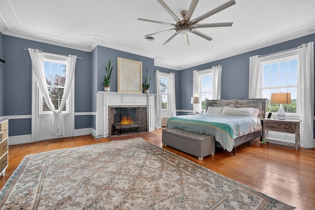 50 Maple Ave, Goshen, NY 10924 - bedroom featuring multiple windows, hardwood / wood-style floors, a fireplace with flush hearth, ornamental molding, and ceiling fan