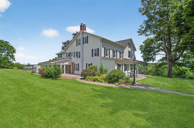 50 Maple Ave, Goshen, NY 10924 - rear view of house with a lawn, a chimney, and a patio area