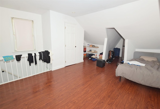 bedroom with vaulted ceiling and wood finished floors