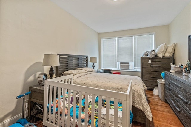 bedroom featuring multiple windows, wood-type flooring, vaulted ceiling, and cooling unit