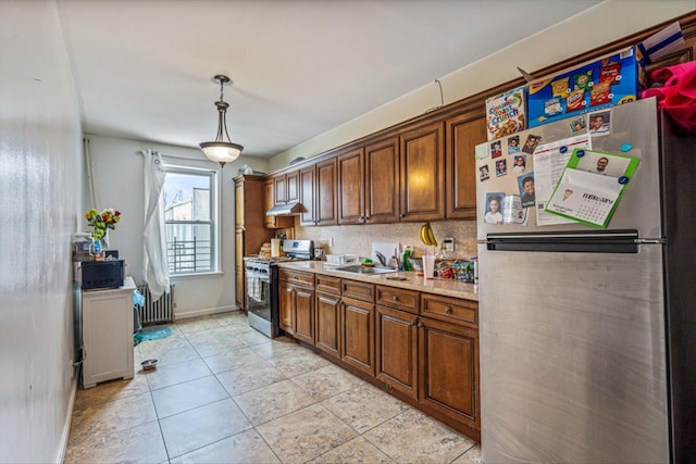 kitchen with appliances with stainless steel finishes, radiator heating unit, decorative light fixtures, backsplash, and light tile patterned floors