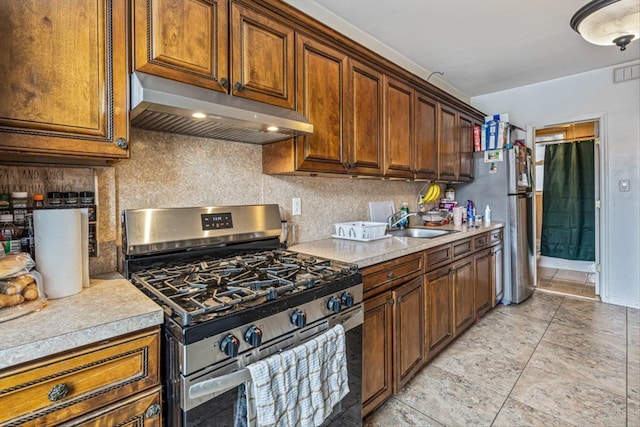 kitchen with appliances with stainless steel finishes, sink, and backsplash