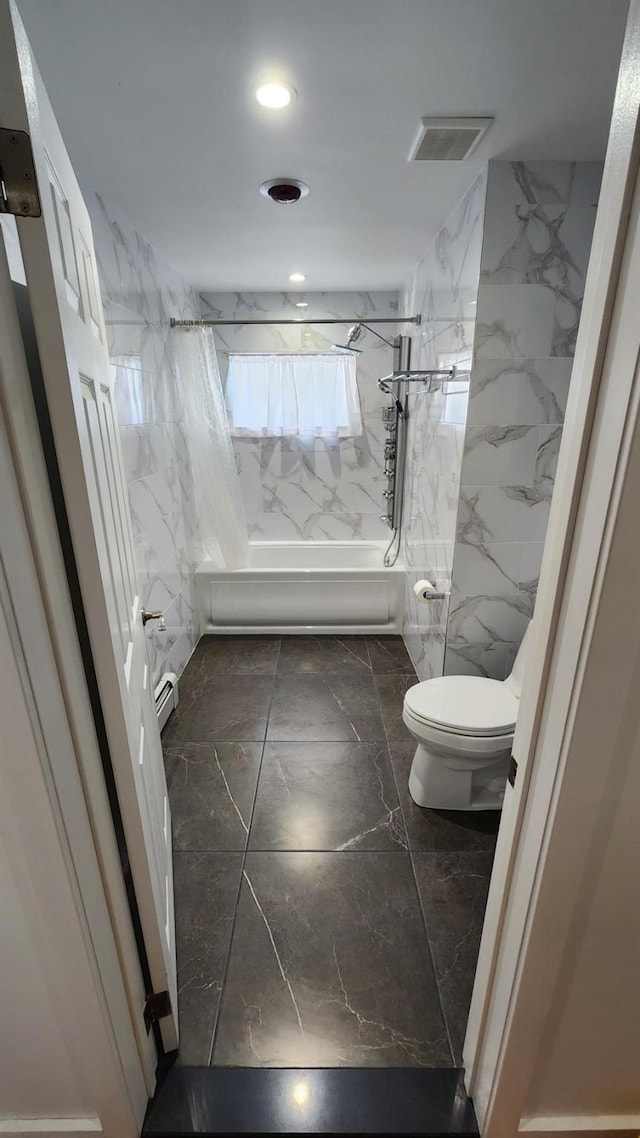 bathroom with tiled shower / bath, tile walls, and toilet