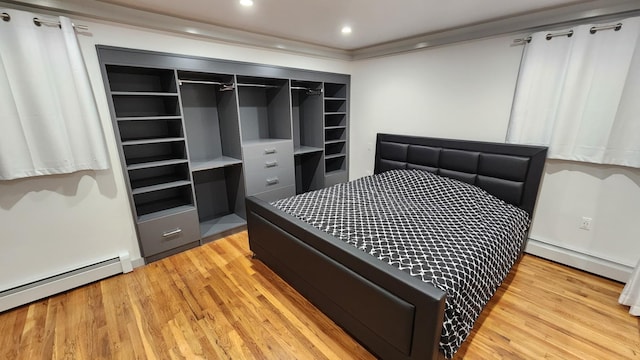 bedroom featuring crown molding, light hardwood / wood-style floors, and baseboard heating