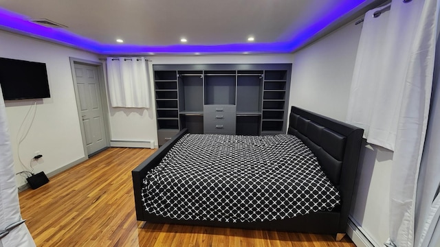 bedroom featuring hardwood / wood-style flooring and a baseboard radiator