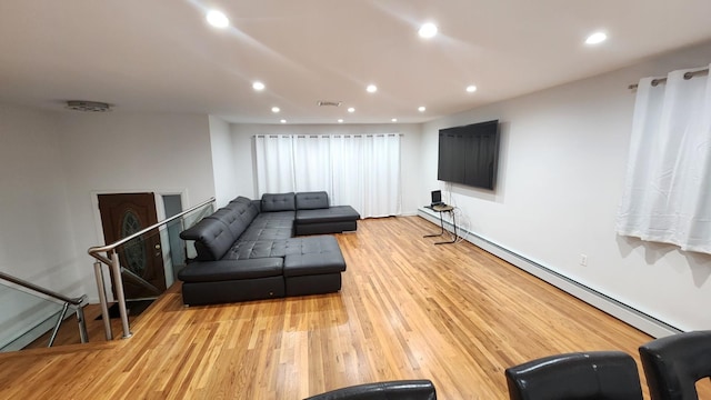 living room featuring a baseboard heating unit and light wood-type flooring