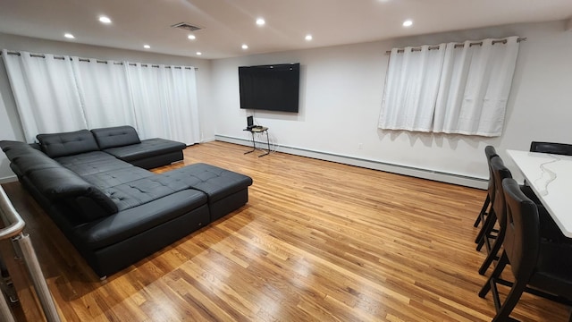 living room featuring baseboard heating and light hardwood / wood-style flooring