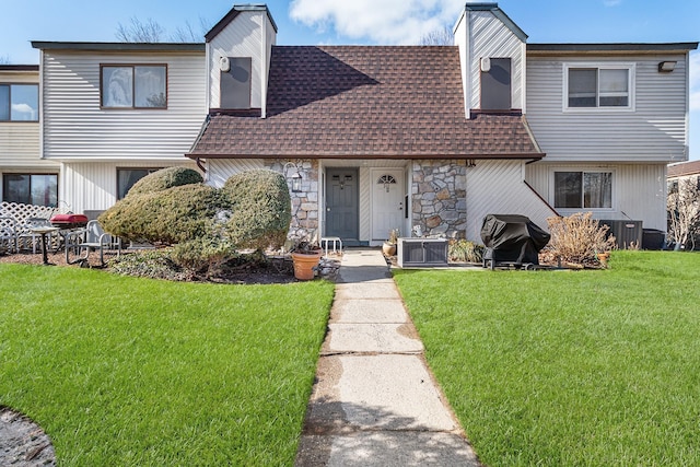 view of property with central AC and a front lawn