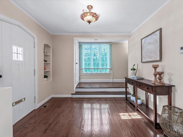 foyer entrance featuring baseboards, wood-type flooring, visible vents, and crown molding