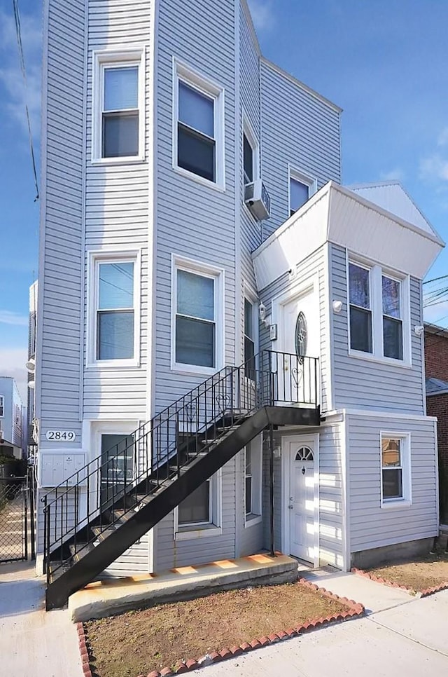 view of property with cooling unit and stairs