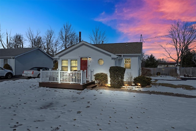 bungalow-style home featuring a garage, fence, and a wooden deck