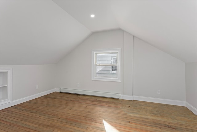 additional living space featuring hardwood / wood-style floors, a baseboard radiator, and vaulted ceiling