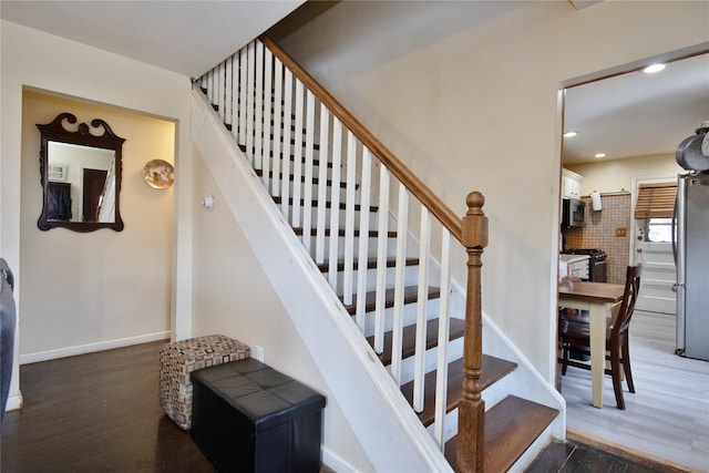 staircase featuring recessed lighting, baseboards, and wood finished floors