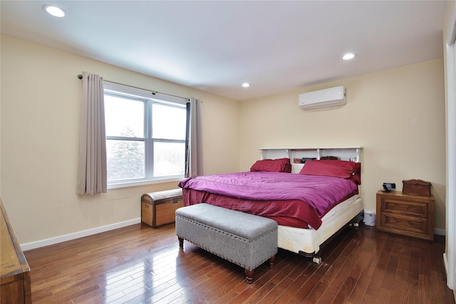 bedroom featuring hardwood / wood-style floors, a wall mounted air conditioner, recessed lighting, and baseboards